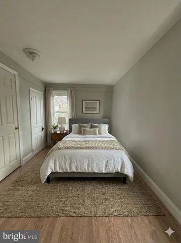 a spacious bedroom with a bed and wooden floor