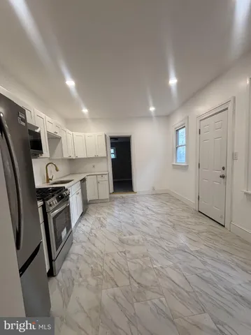 a kitchen with stainless steel appliances granite countertop a refrigerator and a stove