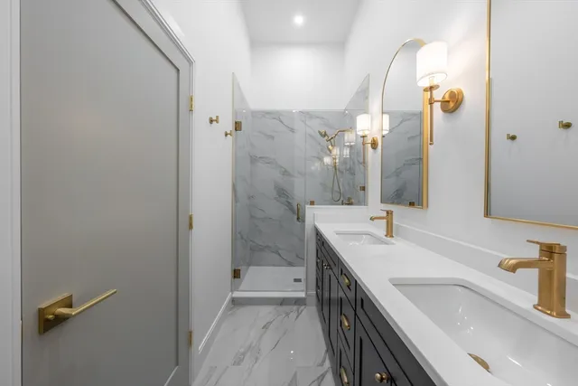 a bathroom with a sink and mirror with shower