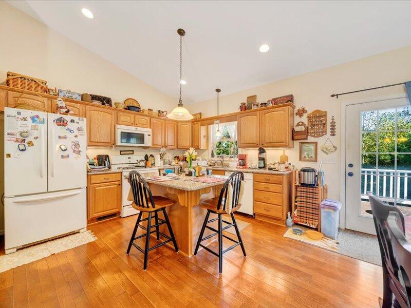 860 Holland Road Callaway, VA 24067 - Photo 13 of 30 a kitchen with stainless steel appliances kitchen island granite countertop a refrigerator a stove top oven and a dining table with wooden floor