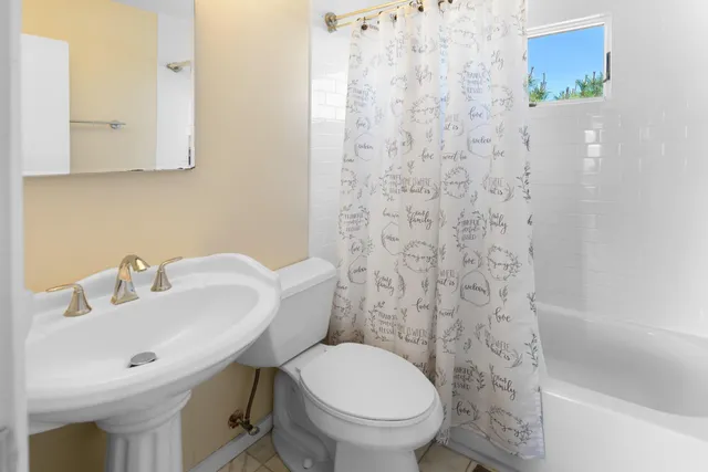 a bathroom with a sink a toilet and a mirror