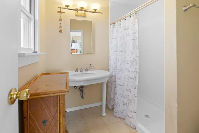 a bathroom with a sink a mirror and a shower