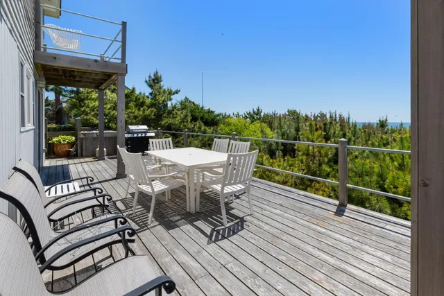 a view of a patio with table and chairs with wooden floor and fence