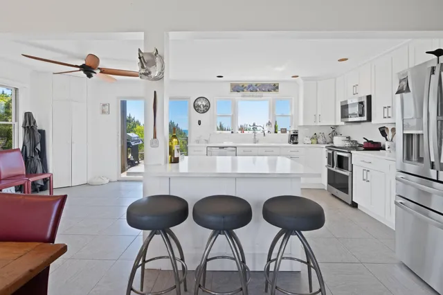 a kitchen with stainless steel appliances a dining table and chairs