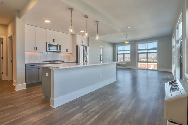 a bathroom with a granite countertop toilet sink and mirror