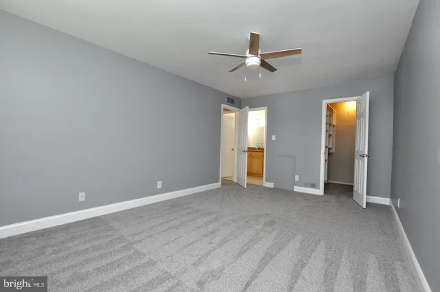 an empty room with closet and windows