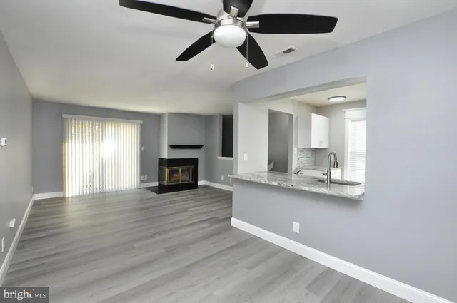 a view of a kitchen with wooden floor and a ceiling fan