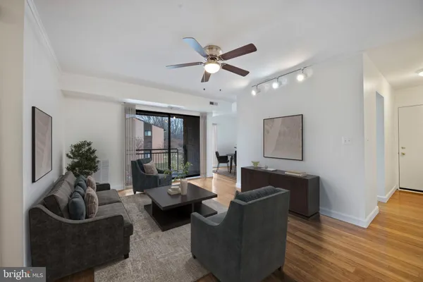 a living room with furniture and a ceiling fan