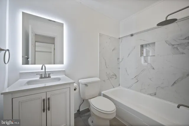 a bathroom with a sink toilet vanity and shower