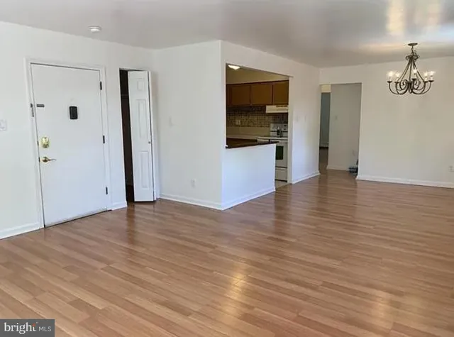 an empty room with wooden floor and entrance