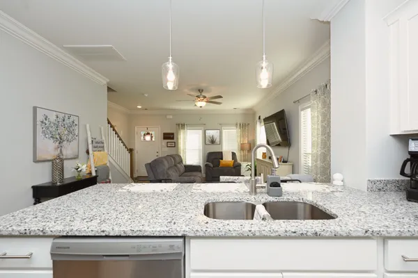 a kitchen with stainless steel appliances granite countertop a stove top oven a sink dishwasher a dining table and chairs with wooden floor