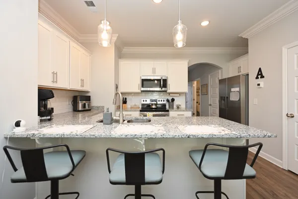 a kitchen with a sink a counter top space appliances and cabinets