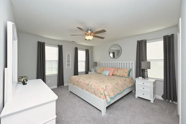 a bedroom with a large bed and a chandelier