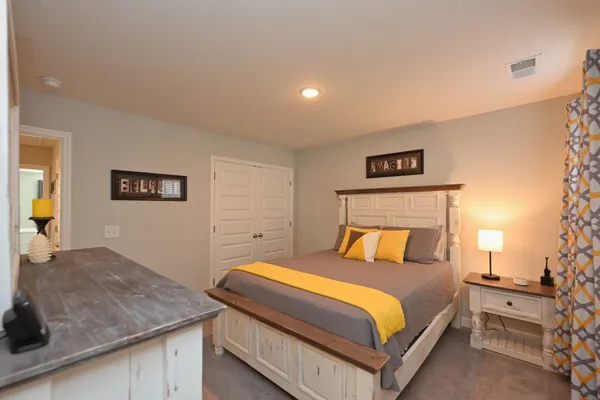 a bedroom with a bed and a lamp on table