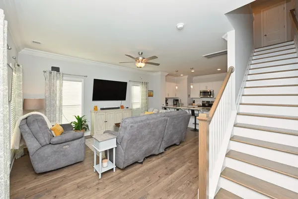 a living room with furniture a flat screen tv and a window