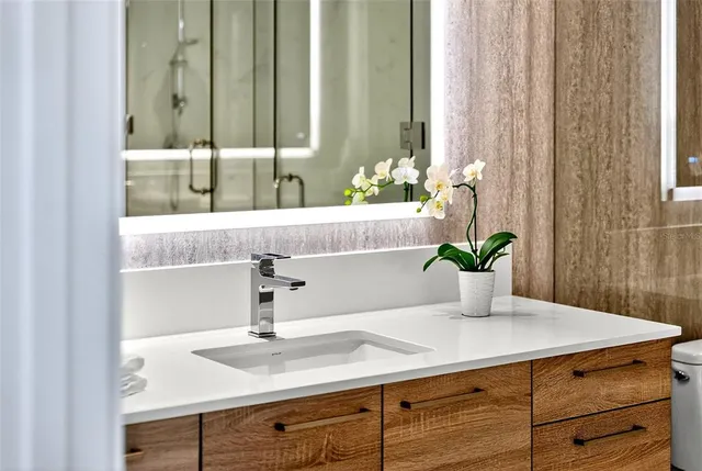 a bathroom with a shower sink and mirror