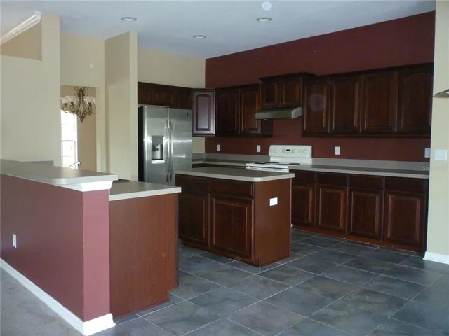 a kitchen with stainless steel appliances granite countertop wooden cabinets a sink and a stove