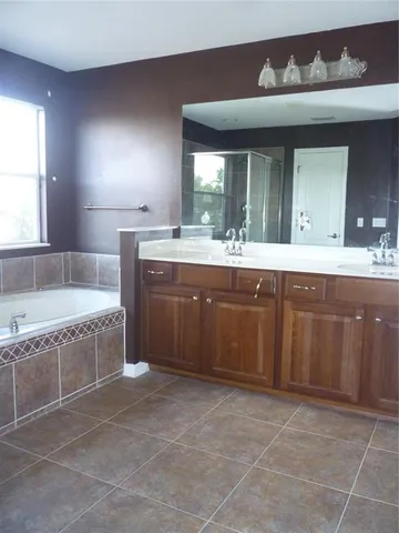 a bathroom with a granite countertop toilet a sink and a window