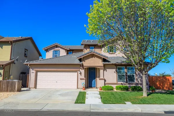 a front view of a house with a garden and trees