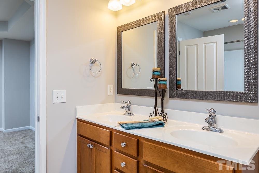 8722 Owl Roost Place Raleigh, NC 27617 - Photo 14 of 26 a bathroom with a sink and a mirror