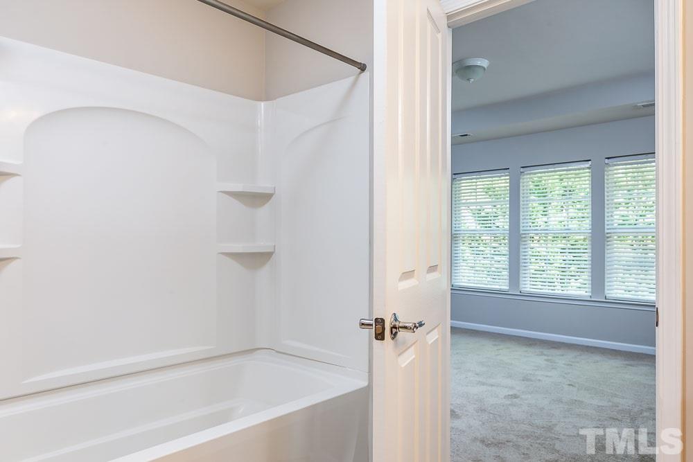 8722 Owl Roost Place Raleigh, NC 27617 - Photo 15 of 26 a bathroom with a bathtub and a shower