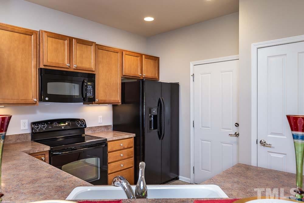 8722 Owl Roost Place Raleigh, NC 27617 - Photo 5 of 26 a kitchen with granite countertop a refrigerator stove and microwave