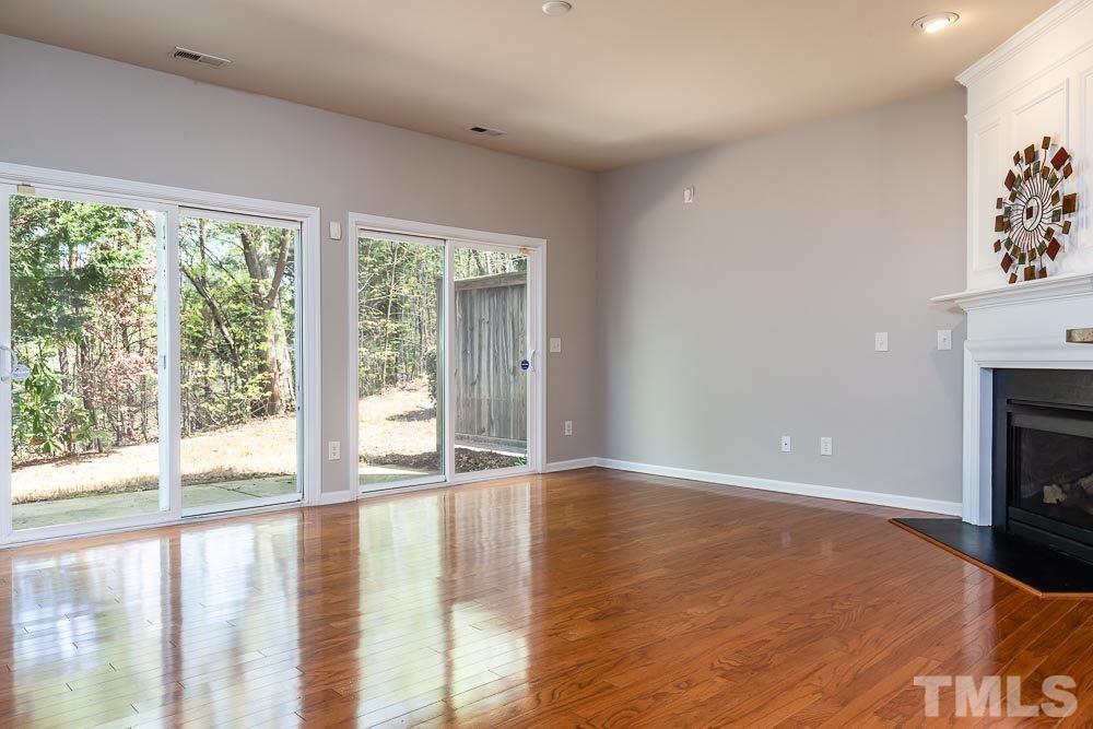 8722 Owl Roost Place Raleigh, NC 27617 - Photo 8 of 26 a view of an empty room with a window and a fireplace