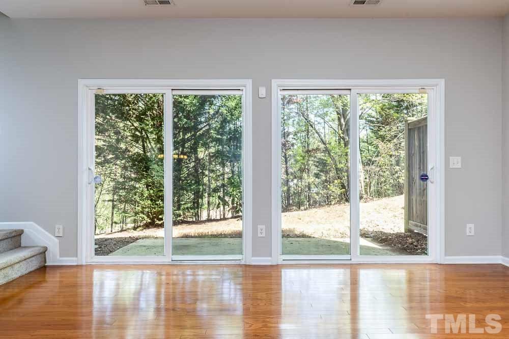8722 Owl Roost Place Raleigh, NC 27617 - Photo 9 of 26 a view of a room with wooden floor and windows