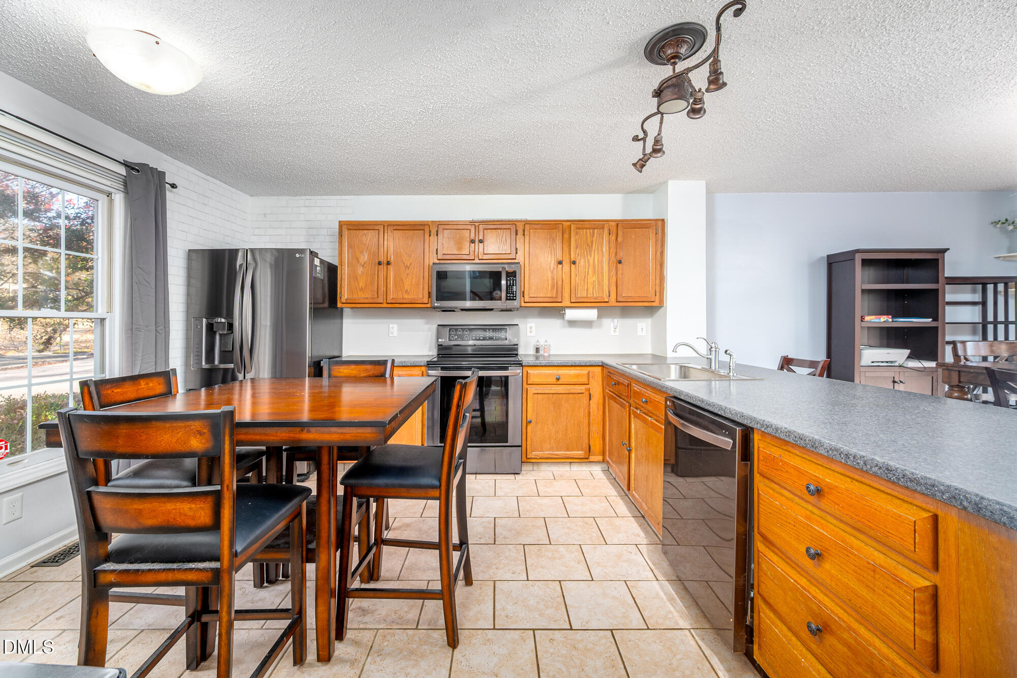 701 Thistlegate Trail Raleigh, NC 27610 - Photo 11 of 53 a kitchen with stainless steel appliances kitchen island granite countertop wooden cabinets a dining table and chairs
