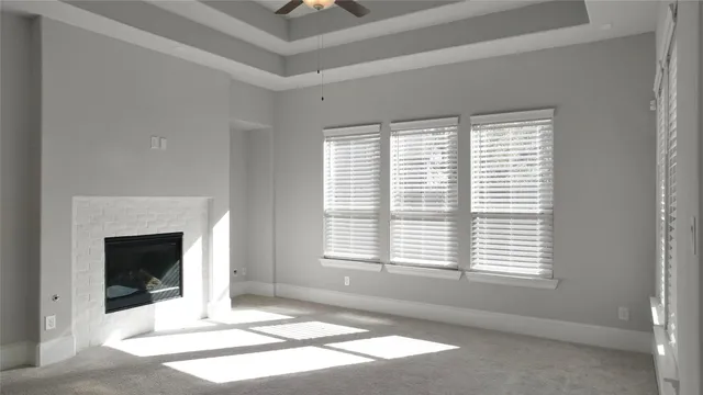 a view of an empty room with a fireplace and a window