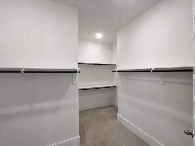 a view of walk in closet with empty racks