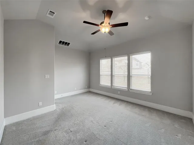 an empty room with windows and fan