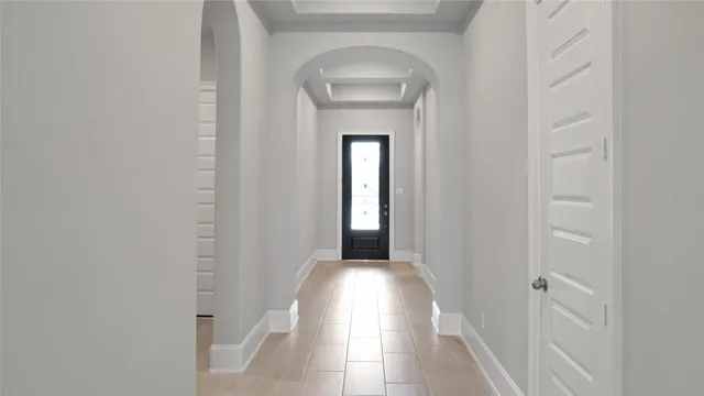a view of a hallway with wooden floor and a white door