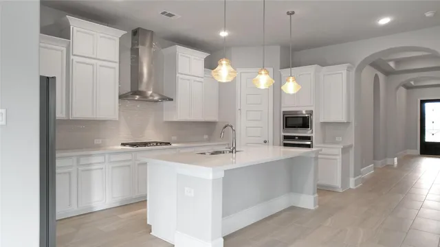 a kitchen with kitchen island a sink stainless steel appliances and cabinets