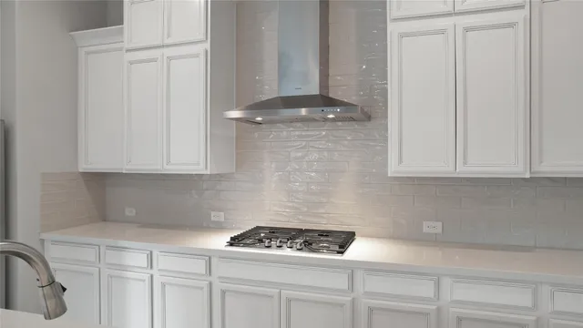 a kitchen with white cabinets and a stove