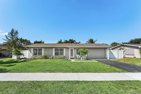 a front view of a house with a garden and yard