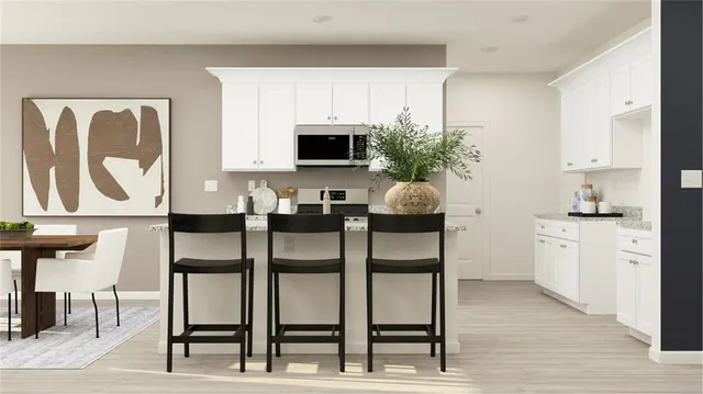 a kitchen with cabinets and chair