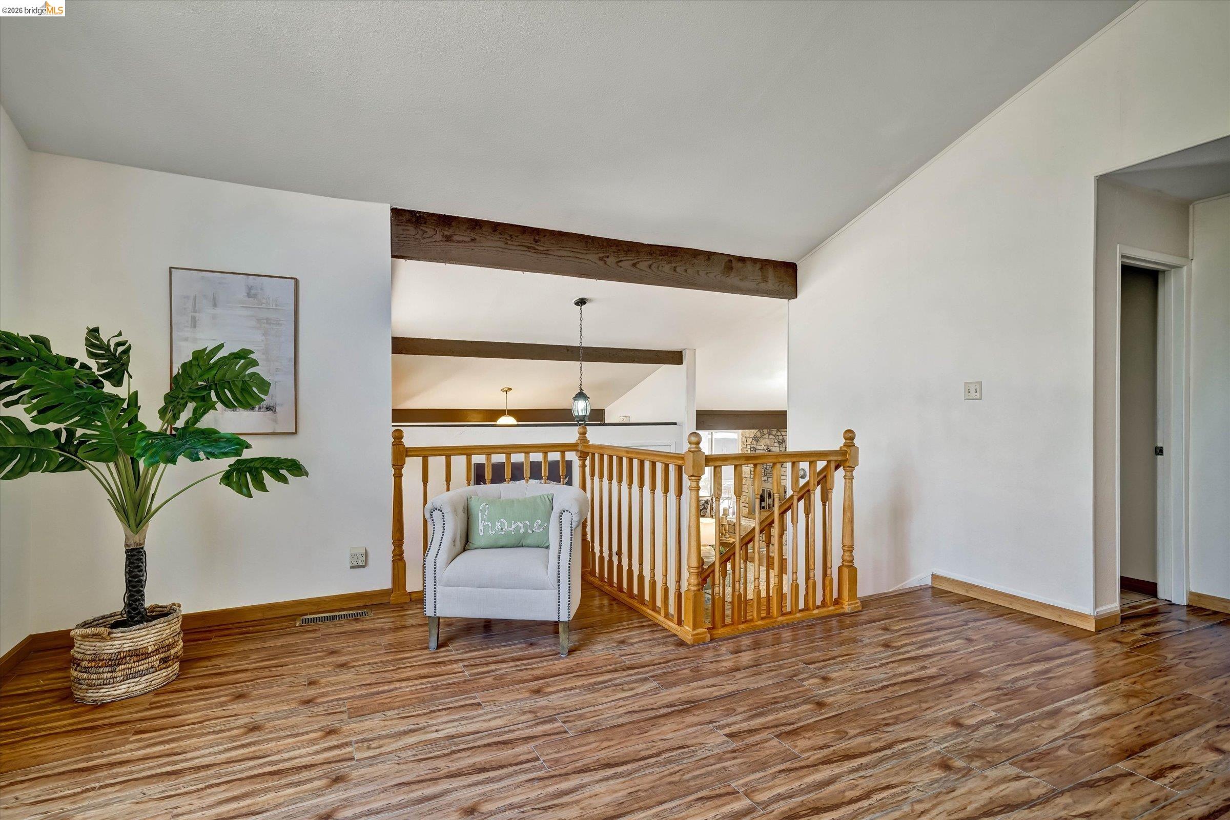 2826 Wright Avenue Pinole, CA 94564 - Photo 38 of 70 Open-concept upper level featuring rich wood-finish flooring, white walls, and a wood beam ceiling accent