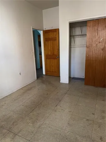 an empty room with closet and wooden door