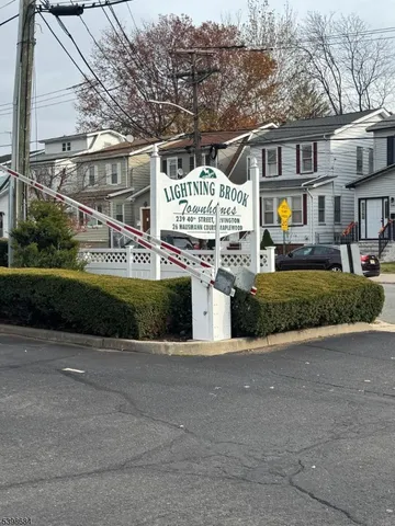 a front view of a house with a garden and tree