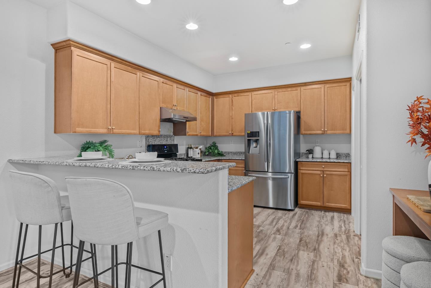 1088 Mallow Terrace San Jose, CA 95133 - Photo 10 of 36 a kitchen with stainless steel appliances granite countertop a refrigerator a stove a sink dishwasher and white cabinets with wooden floor
