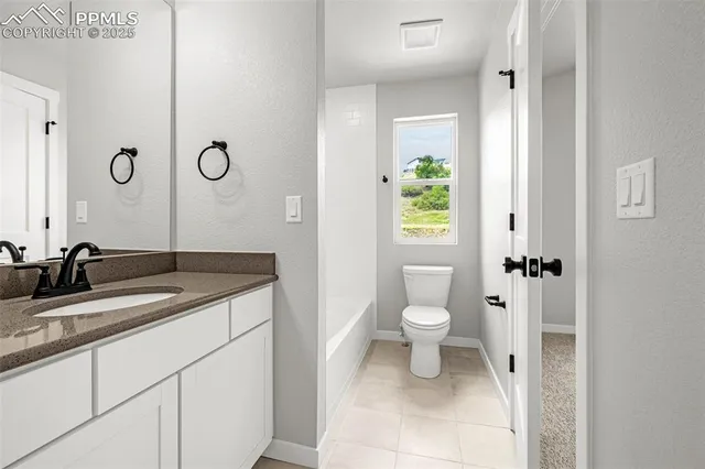 a bathroom with a granite countertop sink a toilet and a mirror