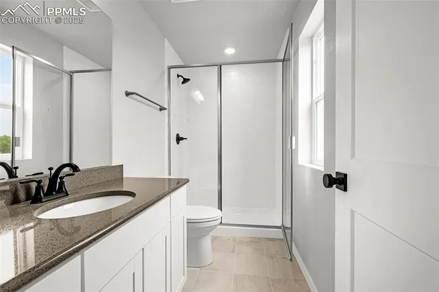 a bathroom with a granite countertop sink a mirror and a shower
