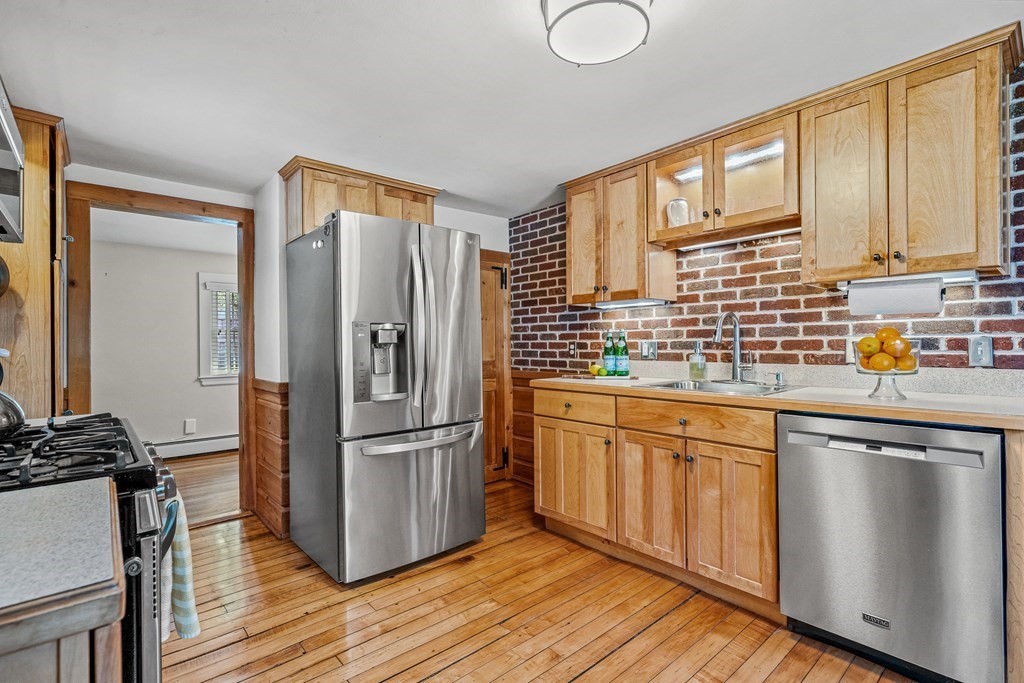 52 Morton Street Andover, MA 01810 - Photo 7 of 27 a kitchen with stainless steel appliances granite countertop a refrigerator a sink dishwasher a stove and white countertops with wooden floor