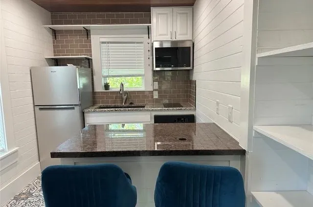 a view of empty room with wooden floor and a bathroom