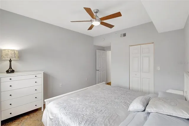 a bedroom with a bed and a ceiling fan