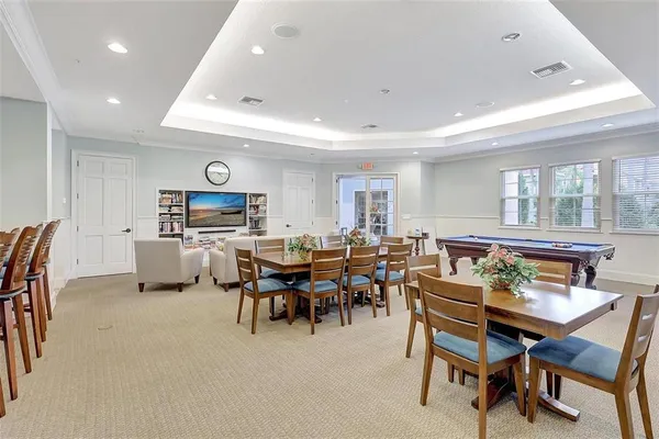 a living room with furniture a dining table and a floor to ceiling window