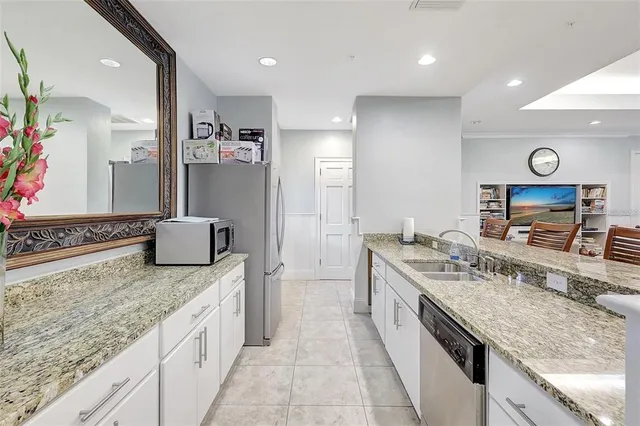 a large kitchen with a granite countertop counter space a sink and stainless steel appliances