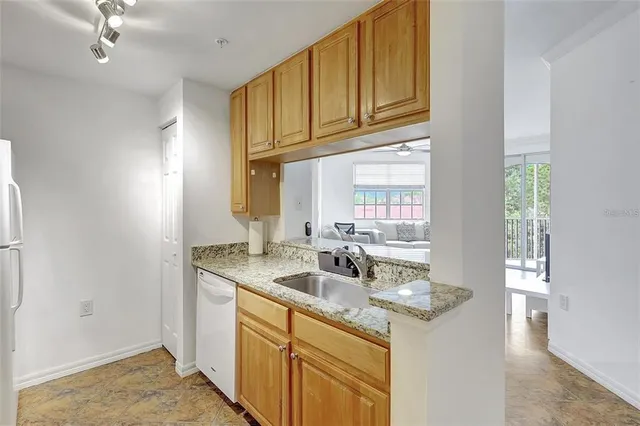 a kitchen with stainless steel appliances granite countertop a sink and dishwasher with wooden cabinets