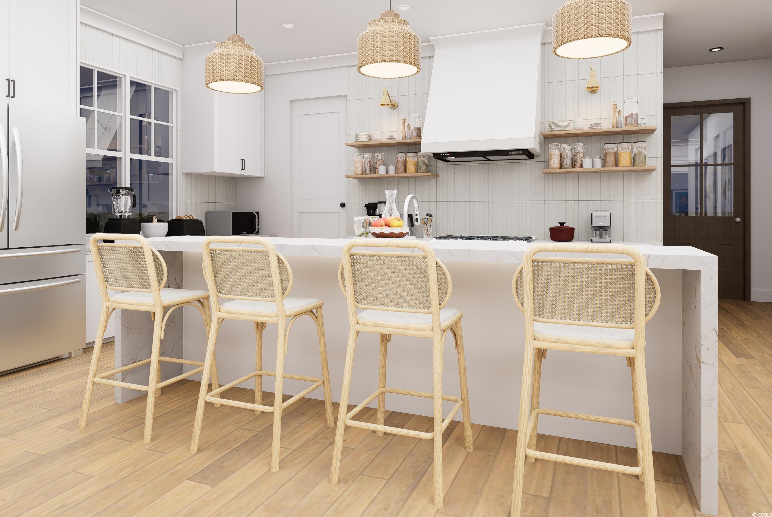 310 King Street Georgetown, SC 29440 - Photo 7 of 23 Kitchen featuring decorative light fixtures, a breakfast bar, stainless steel fridge, premium range hood, and light stone counters